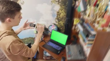 Oğlan odasında şarkı söylüyor.