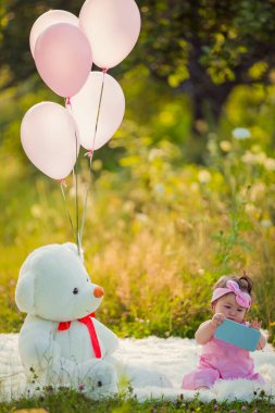 Battaniyenin üzerinde oturan telefonu olan bir kız.