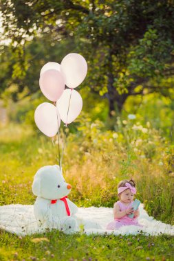 Battaniyenin üzerinde oturan telefonu olan bir kız.