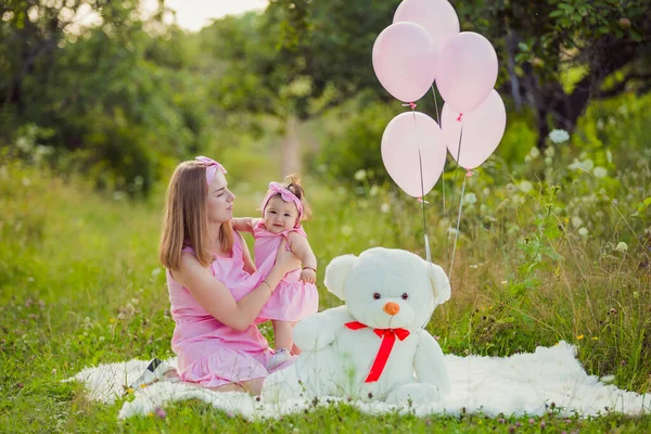 Mor och dotter i rosa klänningar och rosa ballonger — Stockfoto