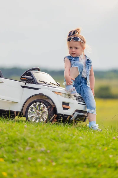 Menina em óculos de sol fica perto do carro — Fotografia de Stock