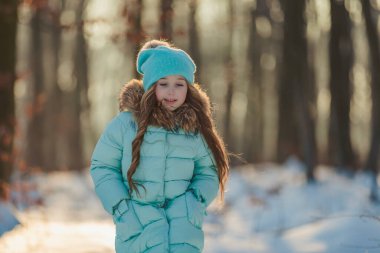 Turkuaz ceketli ve şapkalı kız.