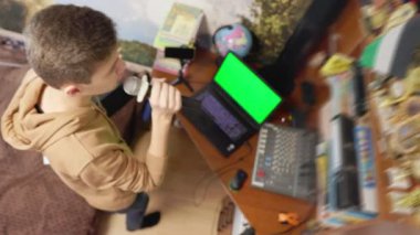 Oğlan odasında şarkı söylüyor.