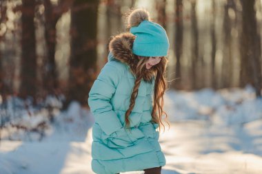 Turkuaz ceketli ve şapkalı kız.