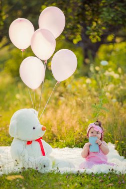 Battaniyenin üzerinde oturan telefonu olan bir kız.