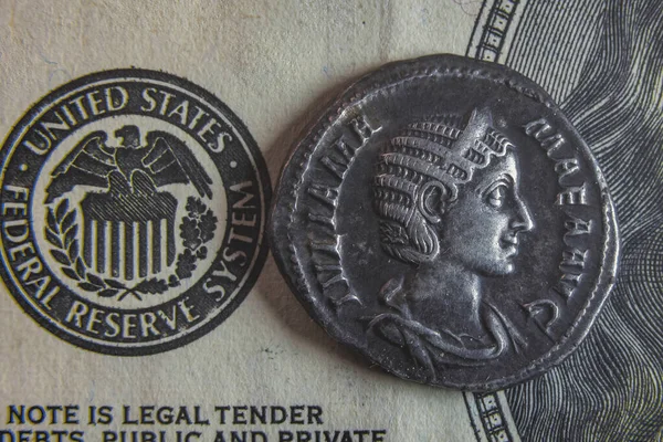 Une vieille pièce romaine repose sur un billet de 100 dollars — Photo