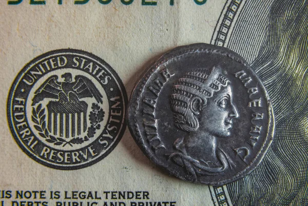 Una vieja moneda romana yace en un billete de 100 dólares —  Fotos de Stock