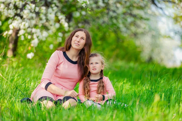 Mother and daughter sitting in green grass —  Fotos de Stock