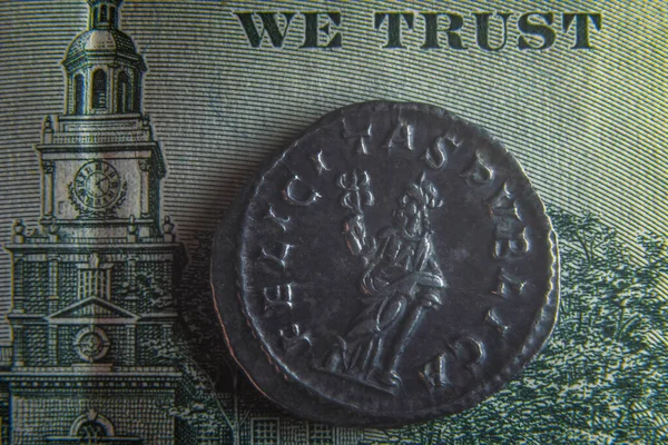 100 달러짜리 지폐 위에 로마의 오래 된 동전이 놓여 있다 — 스톡 사진