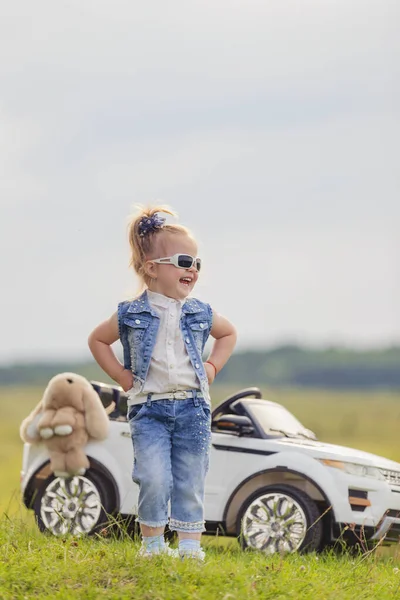 Mädchen mit Sonnenbrille steht neben dem Auto — Stockfoto