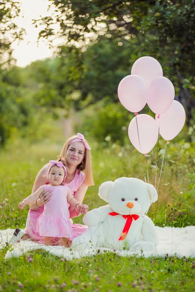 Pembe elbiseli ve pembe balonlu anne-kız.