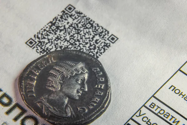 Ένα παλιό νόμισμα σε ένα φύλλο χαρτιού με κωδικό κουάρ — Φωτογραφία Αρχείου