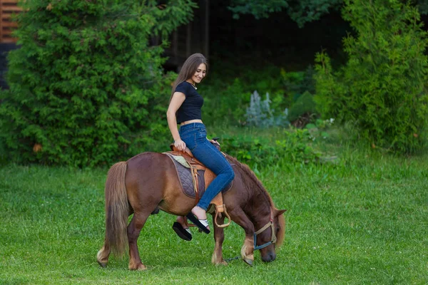 Chica montando un pony — Foto de Stock