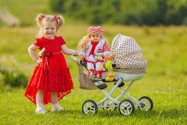 Girl rolls her doll — Stockfoto