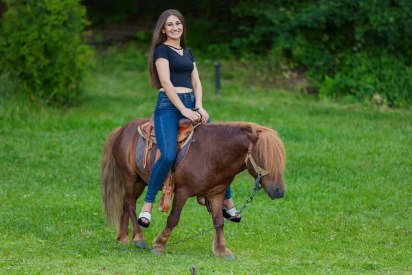 Meisje paardrijden een pony — Stockfoto