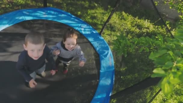 Two children have fun jumping on a trampoline — Stock Video