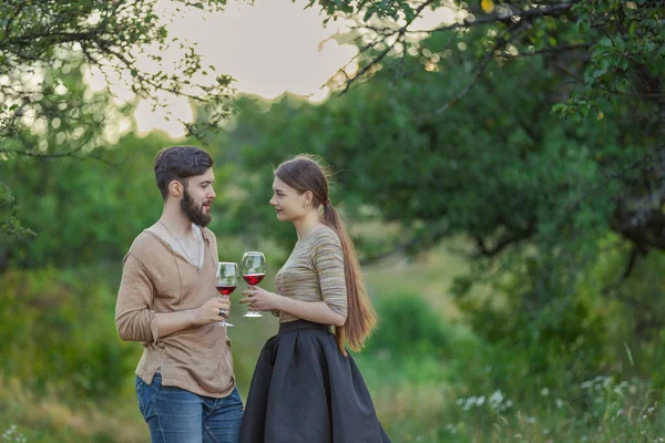 young couple drinking standing drinking wine from glasses