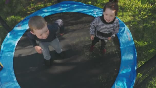 Két gyerek jó szórakozást a trambulinon ugráláshoz. — Stock videók