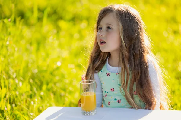 Dziewczyna Szklanką Soku Pomarańczowego Przyrodzie — Zdjęcie stockowe