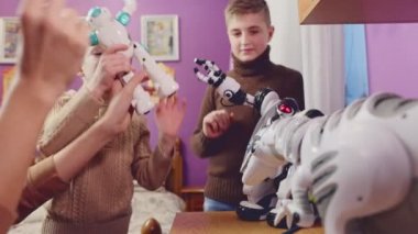 Happy kids playing with toy robots at home