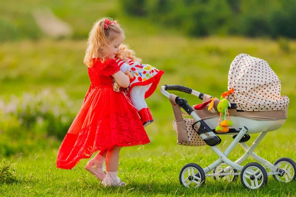 Bir Kız Oyuncak Bebek Arabasına Sarar — Stok fotoğraf
