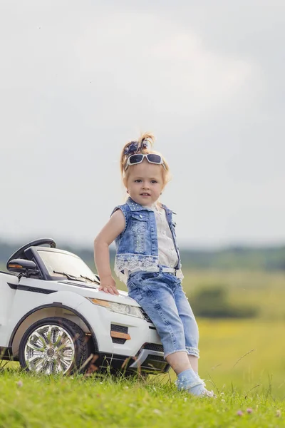赤ん坊の車の近くに立っている少女は — ストック写真
