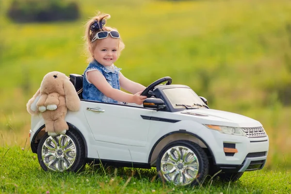 Kleines Mädchen Fährt Auf Kinderwagen Auf Grünem Rasen — Stockfoto