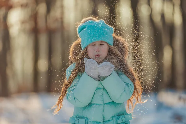 小女孩吹在她手套上的雪上 — 图库照片
