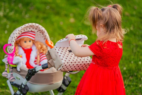 Menina Brinca Com Sua Boneca Que Está Sentado Carrinho Brinquedo — Fotografia de Stock