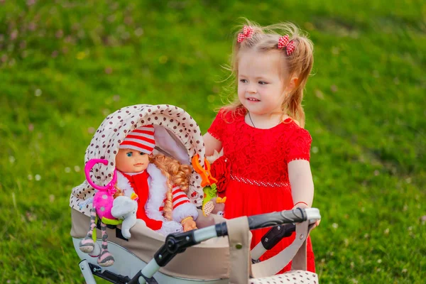 Mädchen Spielt Mit Ihrer Puppe Die Kinderwagen Sitzt — Stockfoto