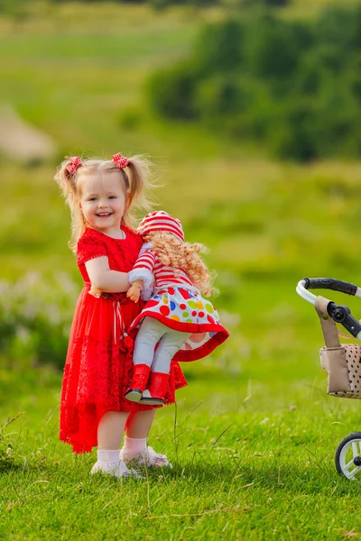 Menina Vestido Vermelho Com Uma Boneca Suas Mãos Fica Natureza — Fotografia de Stock