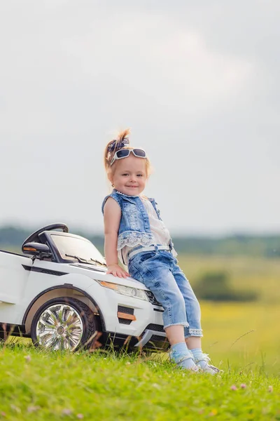 赤ん坊の車の近くに立っている少女は — ストック写真