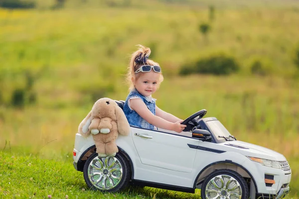 Kleines Mädchen Fährt Auf Kinderwagen Auf Grünem Rasen — Stockfoto