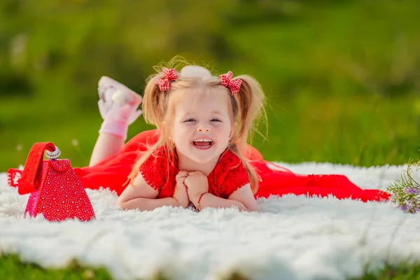 Little Girl Red Dress Lies White Blanket — Stockfoto