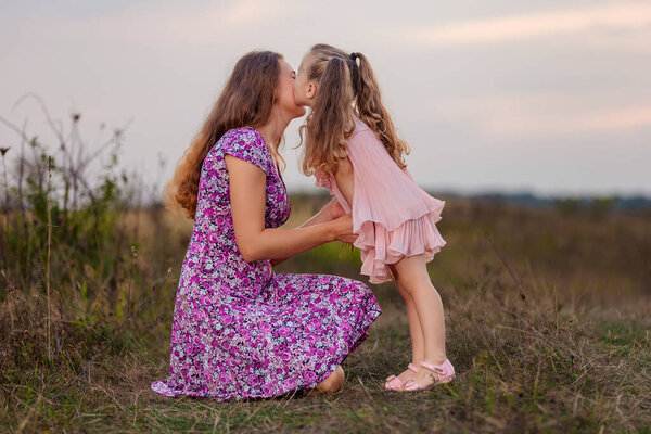 mother with her little daughter walking in nature