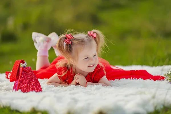 Little Girl Red Dress Lies White Blanket — Stock Photo, Image