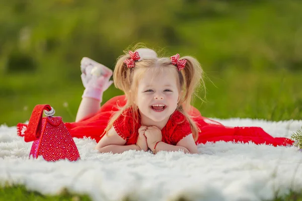 Little Girl Red Dress Lies White Blanket — Stock fotografie