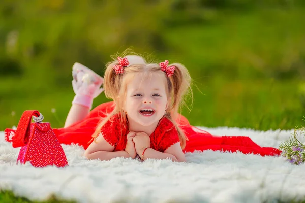 Little Girl Red Dress Lies White Blanket — Stockfoto