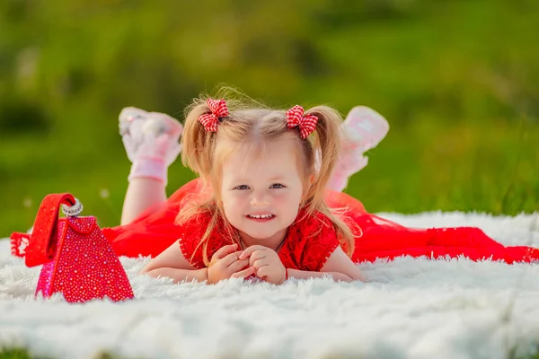 Little Girl Red Dress Lies White Blanket — Stockfoto