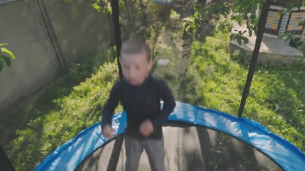 Little Boy Jumps Trampoline Stands Yard — Vídeo de Stock