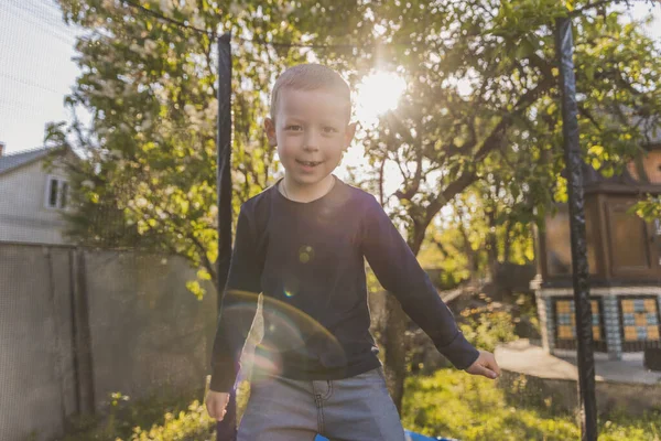 Little Boy Jumps Trampoline Stands Yard — Zdjęcie stockowe