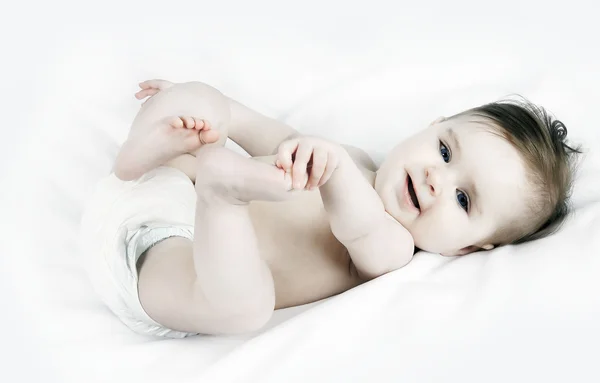 Porträtt av en söt liten baby på vit bakgrund Stockfoto