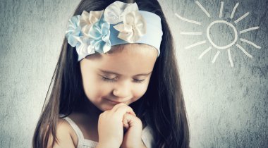 Portrait of little cute girl who prays or dreams clipart
