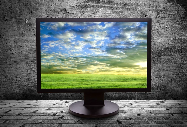 Monitor with thea picture of of pure field against the gray wall — Stock Photo, Image