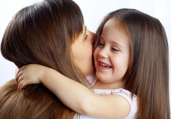 Little cute girl hugging her mother's neck — Stock Photo, Image