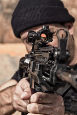 bir makineli tüfek ile işaret eden adam