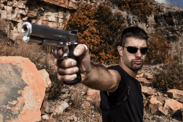 Uomo minaccioso puntando una pistola — Foto Stock