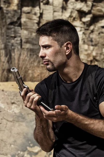 Menacing man reloading a handgun — Stock Photo, Image