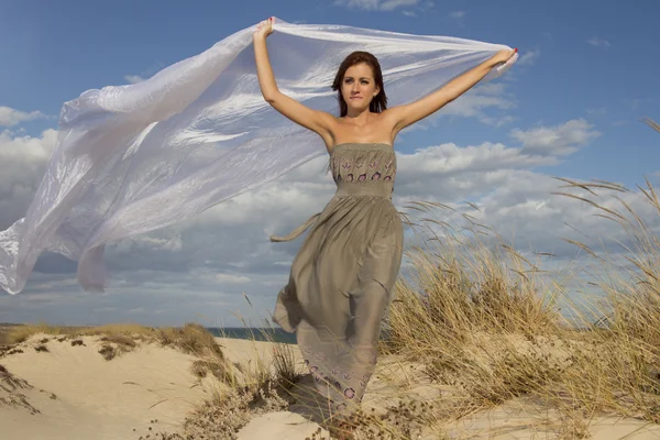 Красивая девушка на пляже с длинной красивой белой тканью — стоковое фото