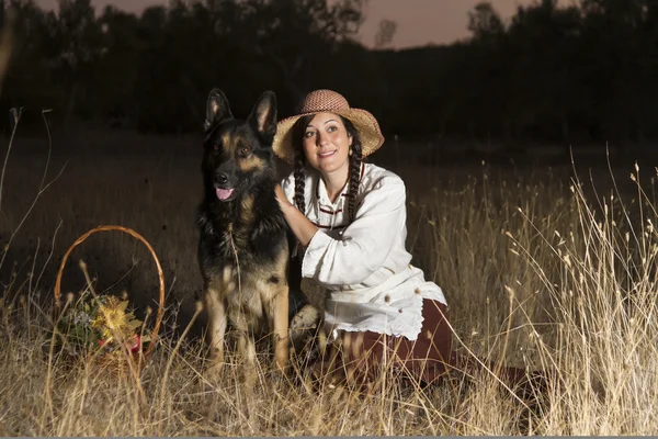 Belle fille à la campagne avec un chien — Photo